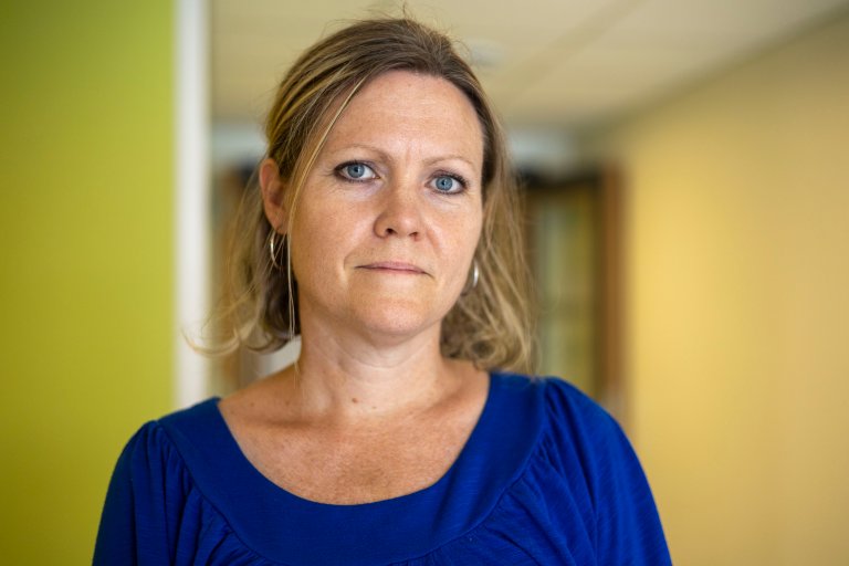 Portrettfoto av en kvinne. Hun har på en blå kjole, og har mellomblondt hår. Hun ser i kamera med et nøytralt ansiktsuttrykk.